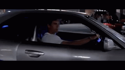 Man Driving Silver Sports Car With Blue Seat Belt