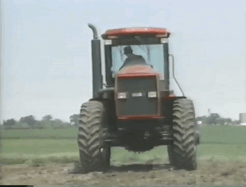 Man Driving Tractor Through Field GIF