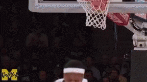 Man Dunking Basketball in Front of Crowd