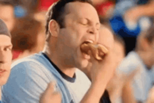Man Eating Hot Dog at Sports Event
