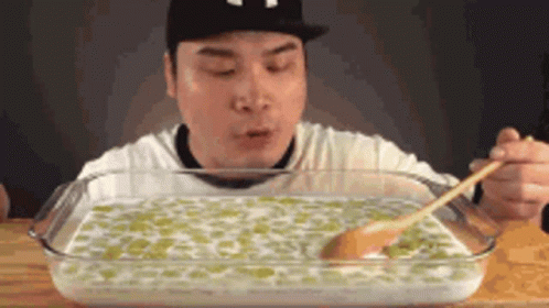 Man Eating Large Amount of Food With Spoon