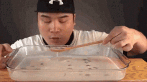 Man Eating Large Amount of Food With Spoon