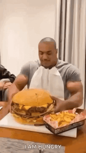 Man Eating Large Hamburger and French Fries