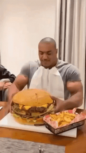 Man Eating Large Hamburger And Fries GIF