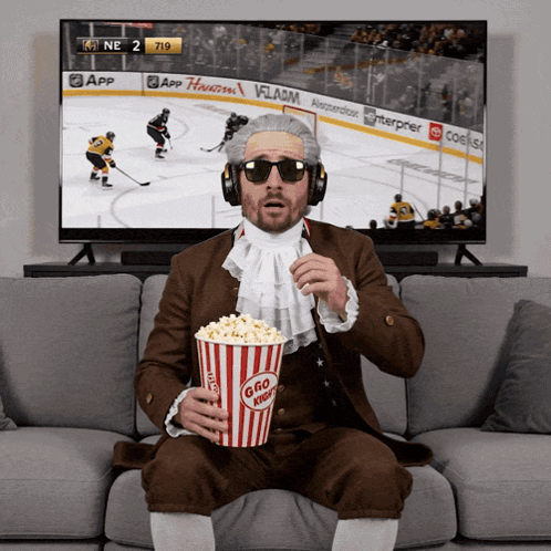 Man Eating Popcorn and Watching Hockey
