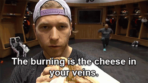 Man Eating Sandwich in Locker Room The Burning Is the Cheese in Your Veins