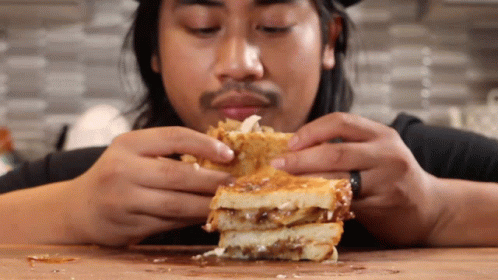 Man Eating Sandwich With Toppings