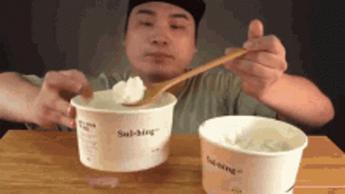 Man Eating Two Cups Ice Cream with Wooden Spoon