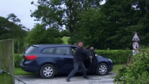 Man Exiting Blue Car With No Turn Sign