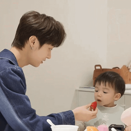 Man Feeding Baby Strawberry with Spoon