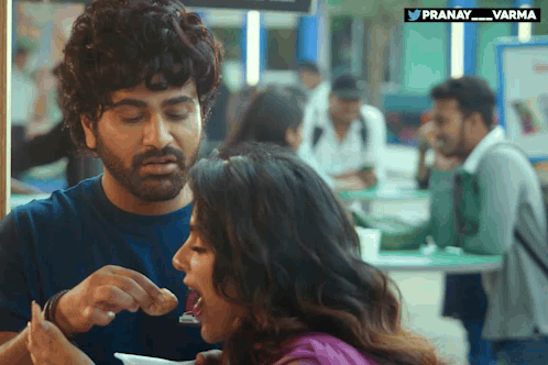 Man Feeding Woman Food with pranay_varma Logo