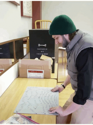 Man Folding Completed Jigsaw Puzzle GIF