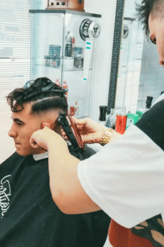 Man Getting Haircut by Barber Wearing LG Shirt