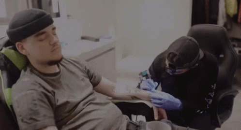 Man Getting Tattoo Wearing Black Hat