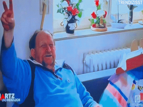 Man Giving Peace Sign in Hospital Bed