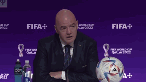 Man Giving Speech Beside Soccer Ball Saying Gay