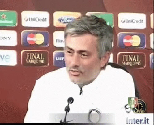 Man Giving Speech in Front of Final Madrid 90 Sign