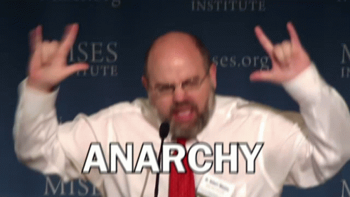 Man Giving Speech with Anarchy Behind