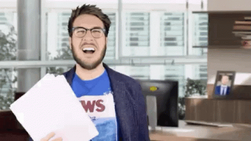 Man Glasses Blue Shirt Saying WS Holding Paper