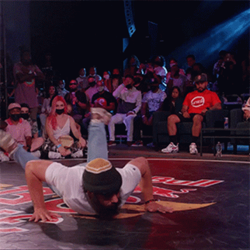 Man Handstanding Before Crowd in Red Bull Shirt