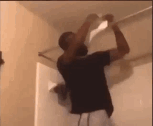 Man Hanging Paper From Ceiling