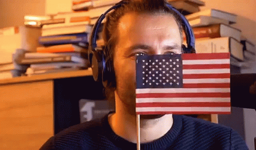 Man Hiding Behind Small American Flag With Headphones