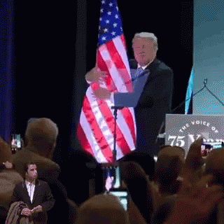 Man Holding American Flag in Front of Crowd