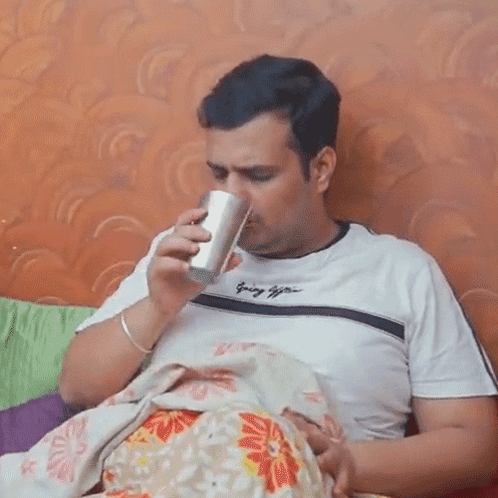 Man Holding Baby and Drinking From Cup
