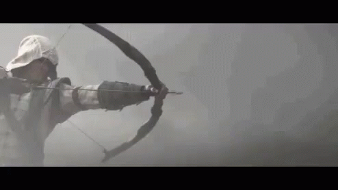 Man Holding Bow and Arrow in Foggy Background