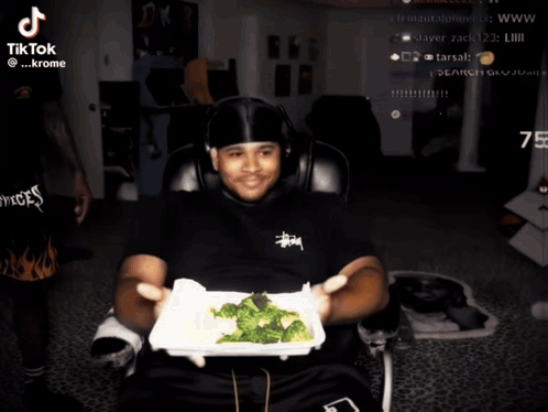 Man Holding Broccoli in Front of TikTok Screen