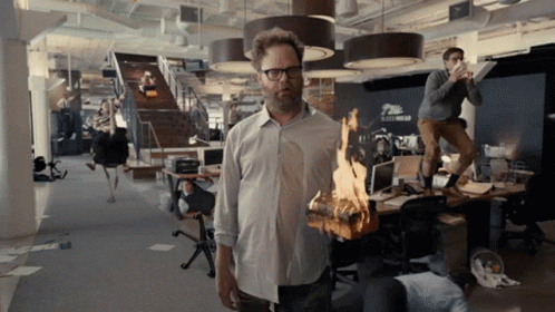 Man Holding Burning Log in Office