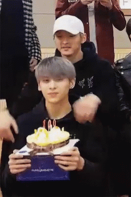 Man Holding Cake With Candles Another Man Watching