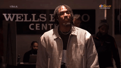 Man Holding Cell Phone In Front Of NBC Sports Philadelphia GIF