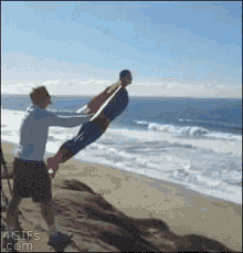 Man Holding Child in Air on Beach