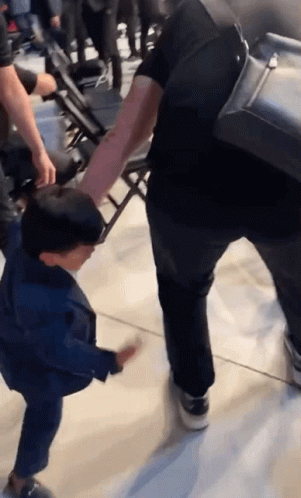 Man Holding Child's Hand Walking Down Hallway