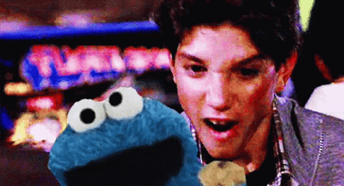 Man Holding Cookie Monster In Front Of Turbo Pinball Machine GIF