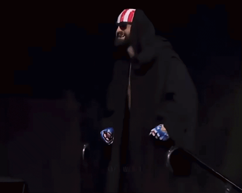 Man Holding Coors Light, Black Cape, Red-White-Blue Headband GIF