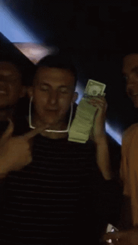 Man Holding Dollars Next to Man in Sunglasses