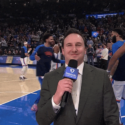 Man Holding FanDuel Microphone at Basketball Game