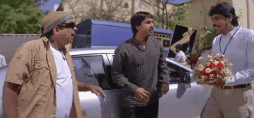 Man Holding Flowers Talking to Two Men