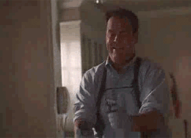 Man Holding Gun and Smiling While Standing in Room