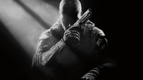 Man Holding Gun in Dark Room
