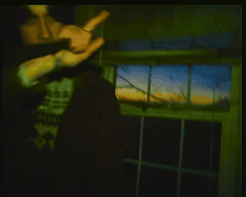 Man Holding Gun in Dark Room With SS Graffiti