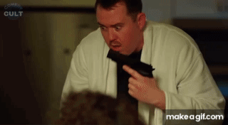 Man Holding Gun In Front Of Comedy Cult Screen GIF