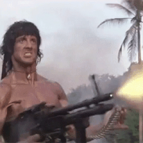 Man Holding Gun in Front of Palm Tree