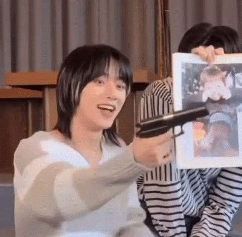 Man Holding Gun in Front of Woman Picture