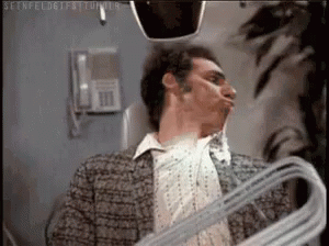 Man Holding Hanger Making Face In Mirror GIF