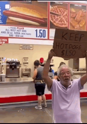 Man Holding Keep Hot Dogs $1.50 Sign
