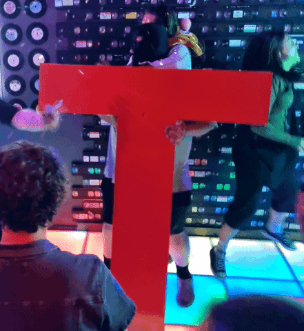Man Holding Large Red Letter T