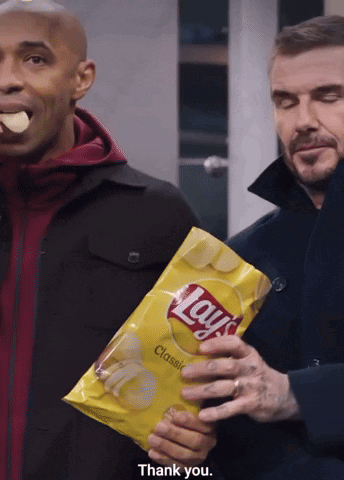 Man Holding Lays Chips While Another Eats